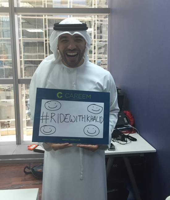 Khalid Al Ameri holding his #RideWithKhalid sign at Careem offices